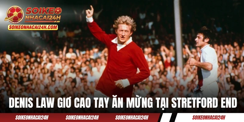 Denis Law giơ cao tay ăn mừng bàn thắng tại Stretford End